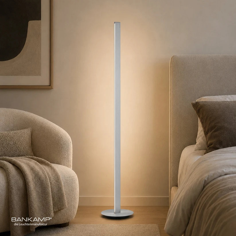Bankamp STRAIGHT vloerlamp in aluminium mat naast een fauteuil en bed Bankamp Straight vloerlamp aluminium mat