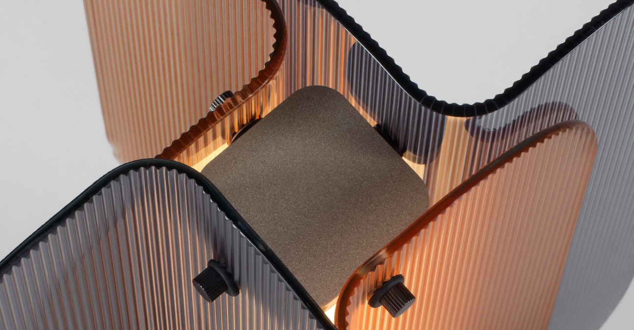 Detail van de Quasar Fold tafellamp met geribbelde glaspanelen in verschillende kleuren en warme LED-verlichting