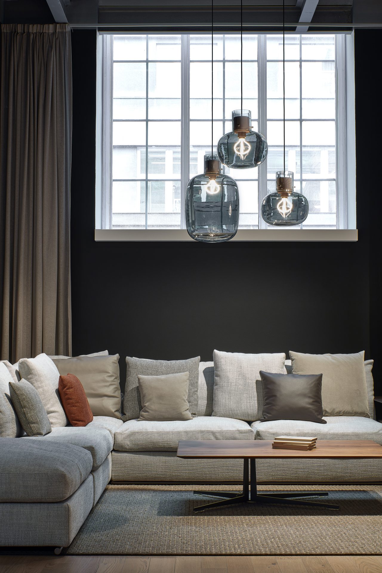 Brokis Awa compositie met smoke grey glas en Amerikaans notenhout Brokis Awa hanglampen in smoke grey glas boven zithoek