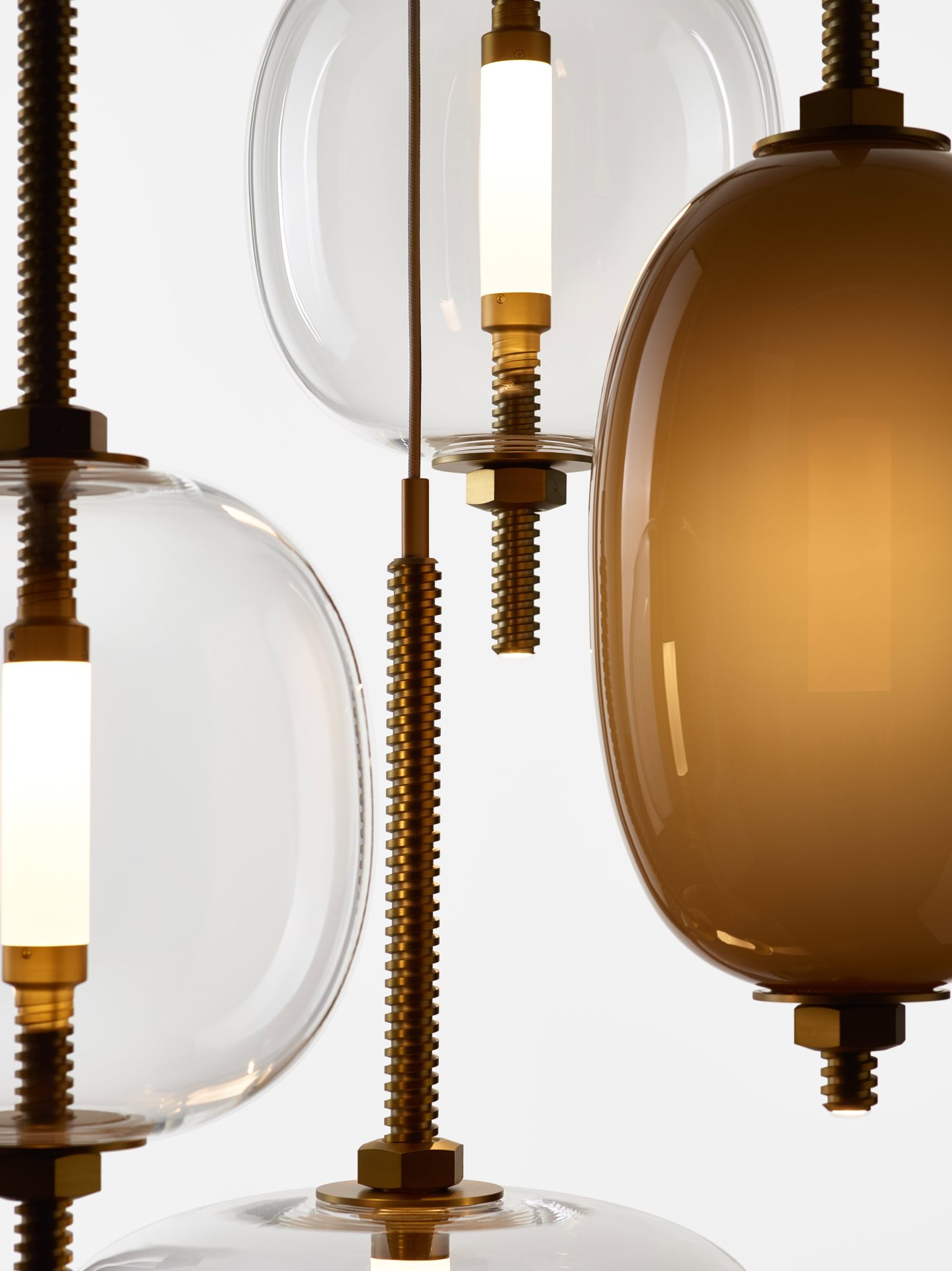 Under Pressure – detail glas en champagnekleurig metaal Detail van Brokis Under Pressure hanglampen Vertical Little en More in parelbruin opaalglas en transparant glas met geborsteld champagnekleurig metaal