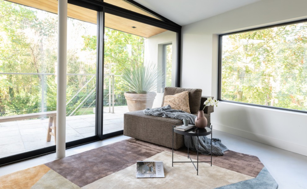 Astrada handgetuft vloerkleed in modern interieur met grote raampartijen Munk Carpets handtuft Astrada karpet met geometrisch dessin in een lichte woonkamer